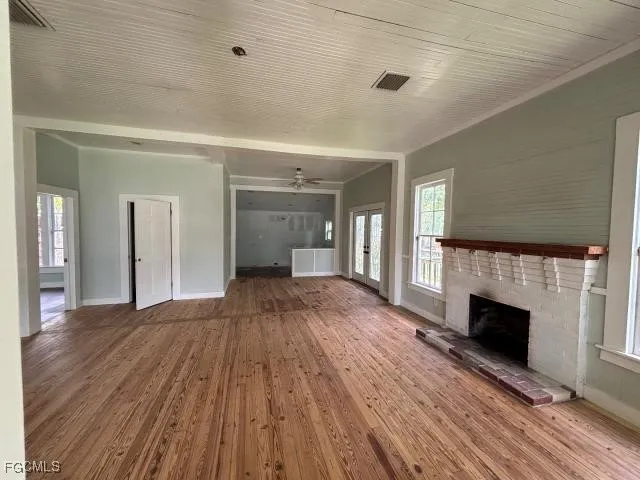 a view of empty room with wooden floor and fireplace