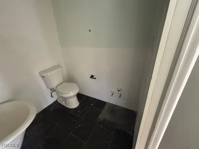 a bathroom with a toilet and a mirror