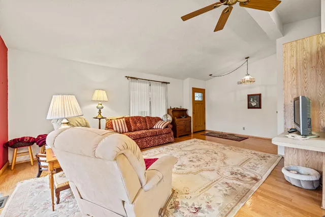 a living room with furniture ceiling fan and a wooden floor