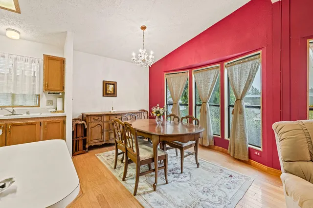 a dining room with furniture a chandelier and wooden floor