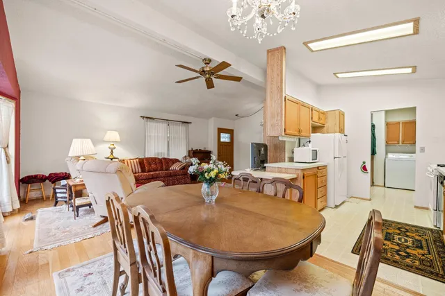 a living room with furniture a chandelier and kitchen view