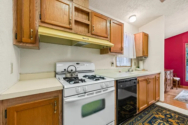 a kitchen with stainless steel appliances granite countertop a stove a sink and a refrigerator