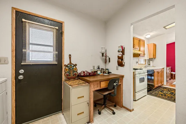 a view of a workspace with furniture and a window