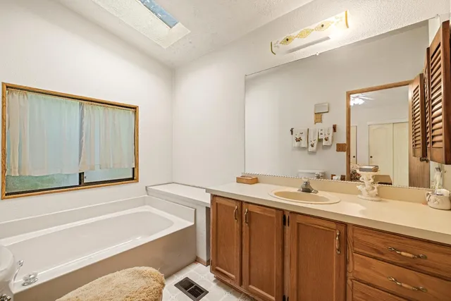 a bathroom with a tub sink and a mirror