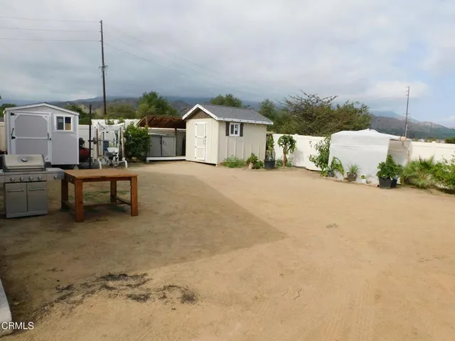 a view of a house with backyard and sitting area