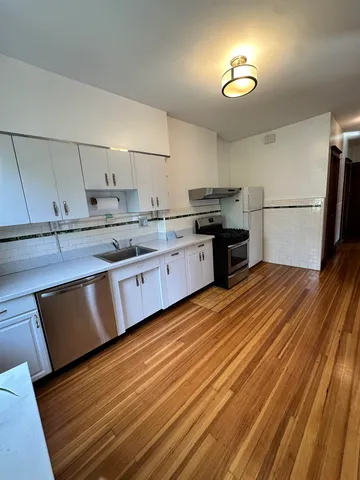 a kitchen with stainless steel appliances granite countertop a sink dishwasher stove and refrigerator