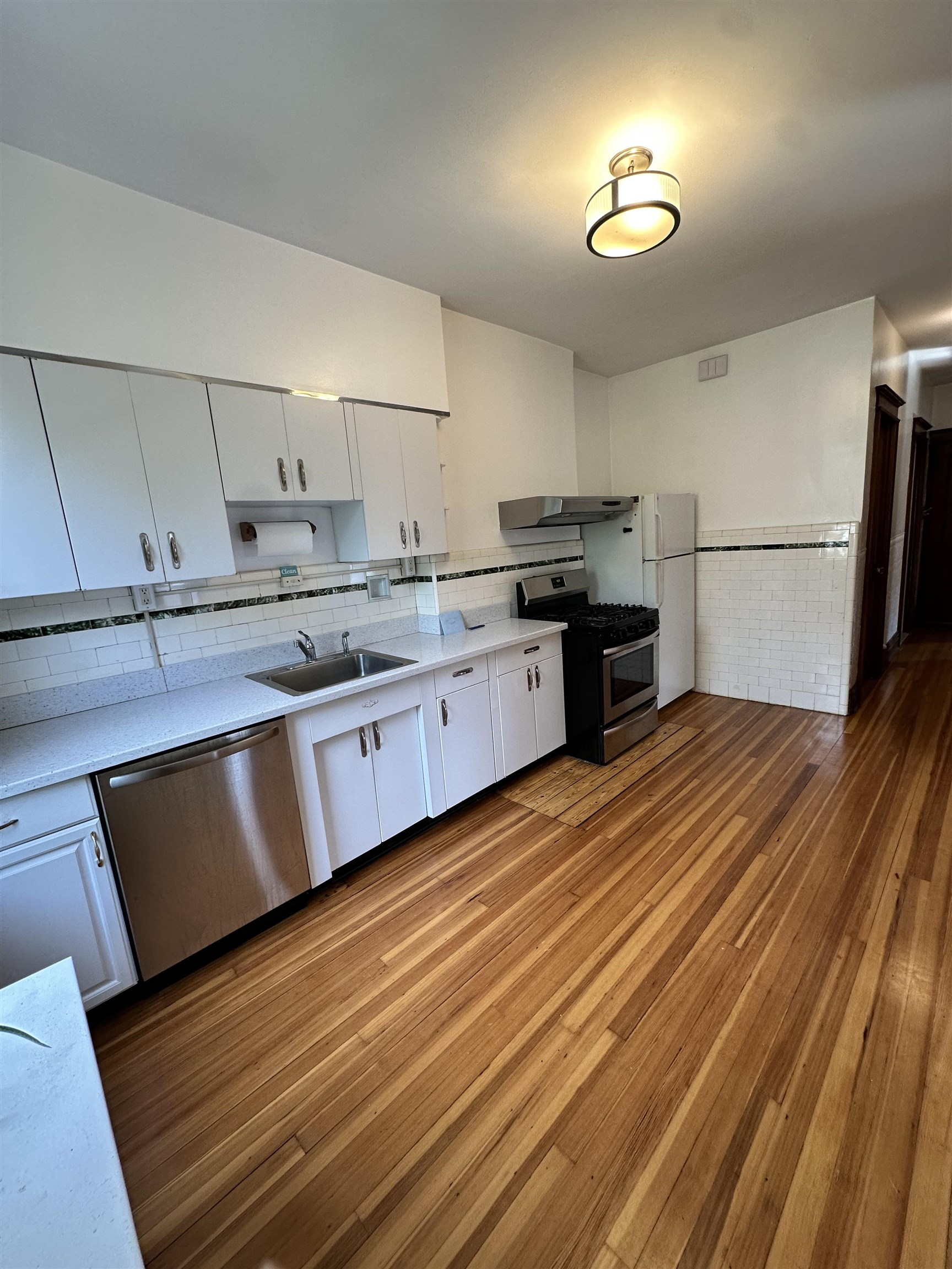 22 46th Street, Unit 2 Weehawken, NJ 07086 - Photo 5 of 7 a kitchen with stainless steel appliances granite countertop a sink dishwasher stove and refrigerator
