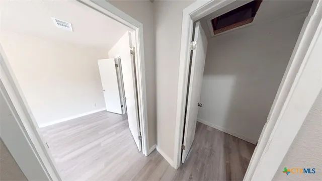a view of a hallway with wooden floor