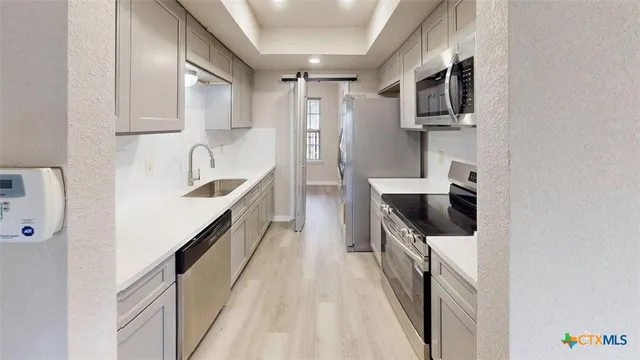 a kitchen with stainless steel appliances granite countertop a sink and a stove