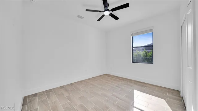 a view of a big room with wooden floor and windows