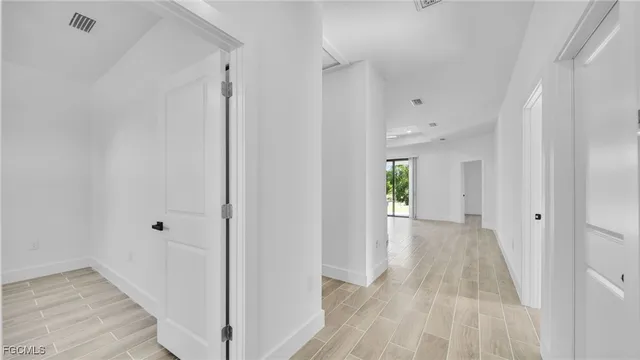 a view of a hallway with wooden floor and closet area