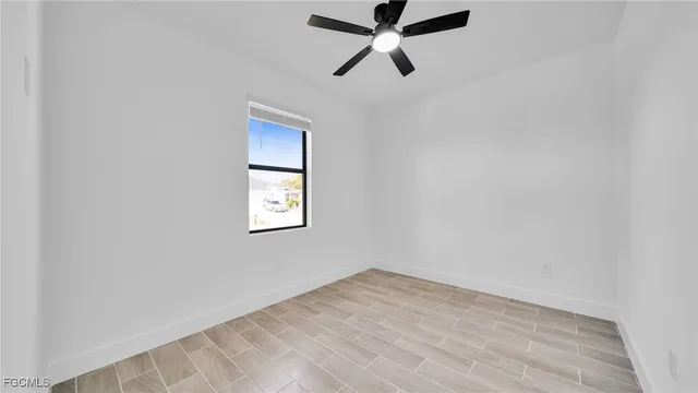 an empty room with a window and a fan