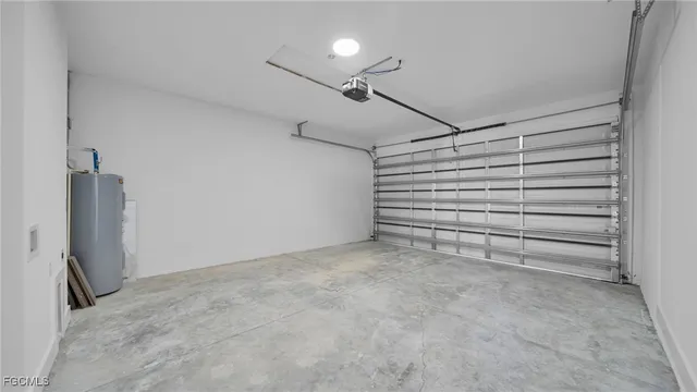 a backyard of a house with plants and large tree