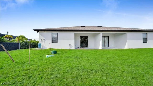 a view of a backyard with plants and wooden fence
