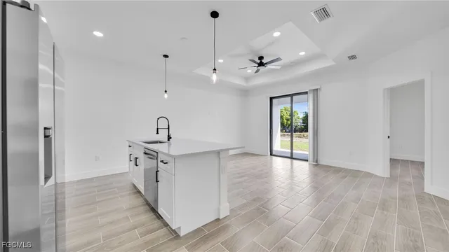 a view of a kitchen with a sink wooden floor and a window
