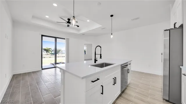 a kitchen with stainless steel appliances a sink and wooden floor