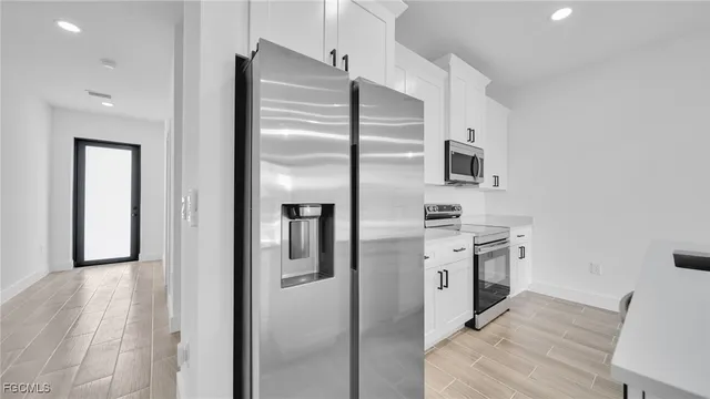 a kitchen with stainless steel appliances granite countertop a refrigerator a stove and a sink