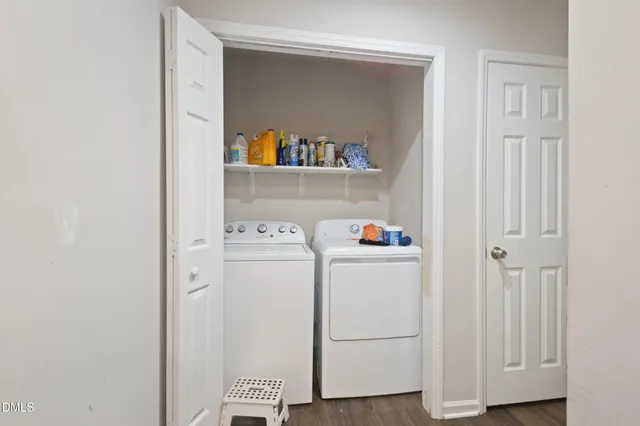 a view of a hallway with wooden floor and a bathroom