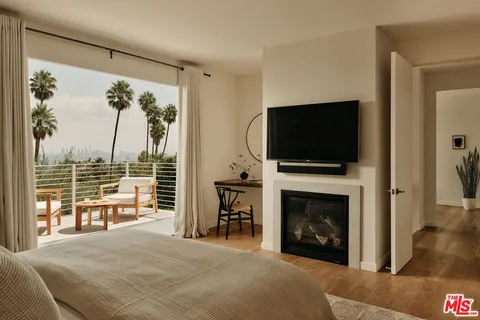 a bedroom with a bed and a flat screen tv
