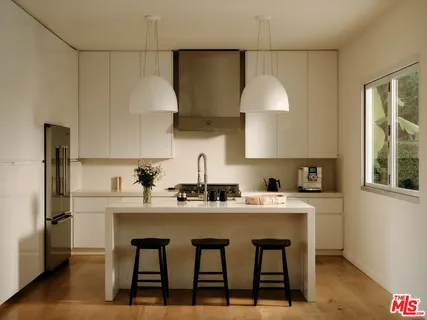 a kitchen with stainless steel appliances a sink a stove a refrigerator and cabinets
