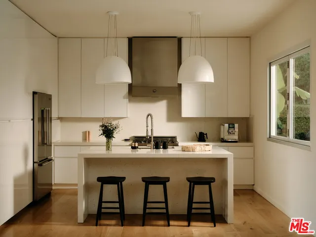 a kitchen with stainless steel appliances a sink a stove a refrigerator and cabinets