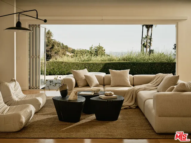a living room with furniture and a floor to ceiling window
