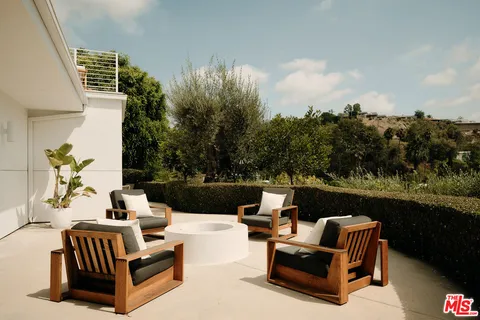 a view of a terrace with couches chairs and a yard