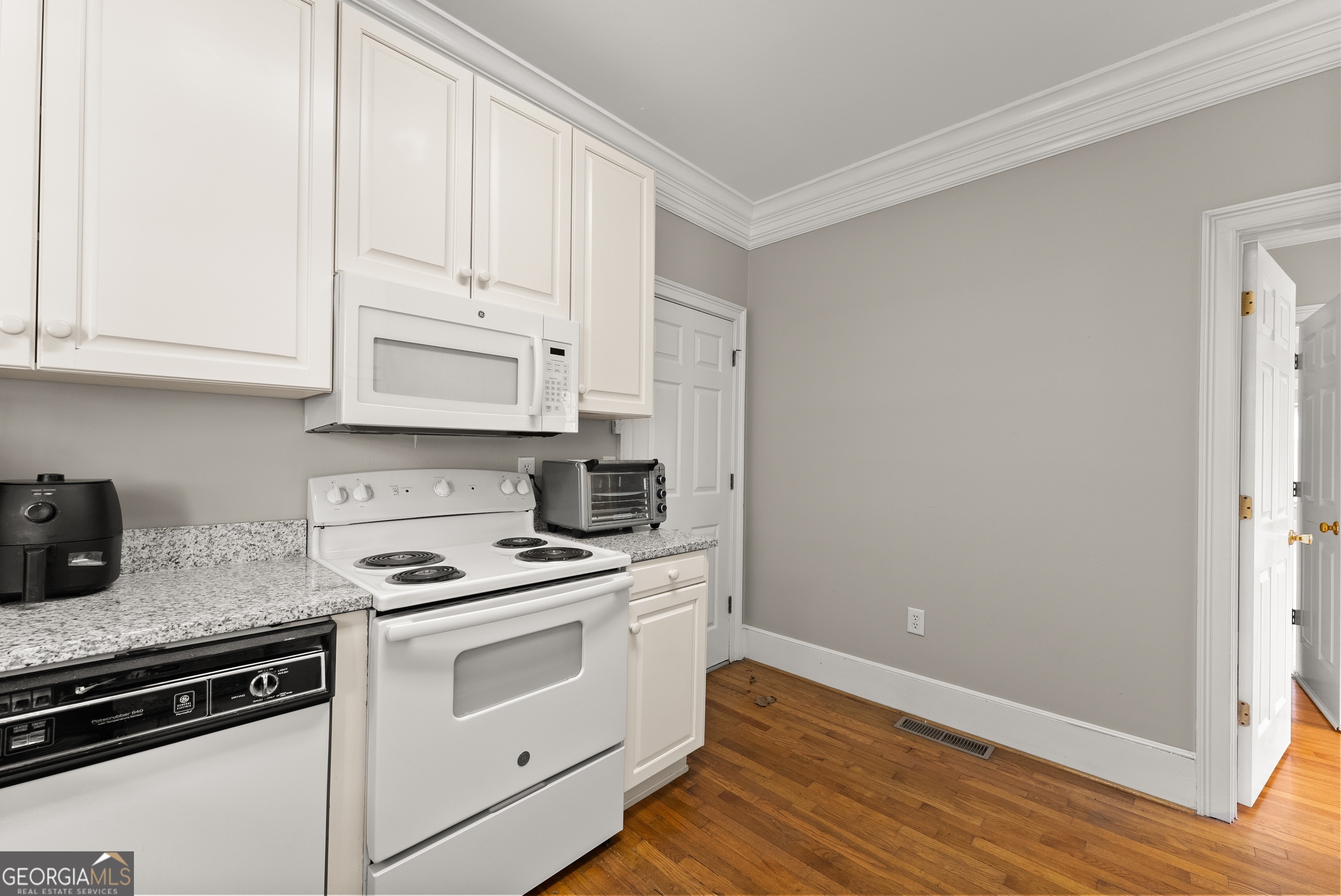 592 North Main Street Cornelia, GA 30531 - Photo 12 of 41 a kitchen with granite countertop white cabinets and white appliances