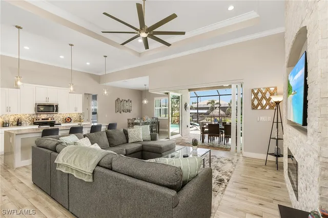 a living room with furniture kitchen view and a large window