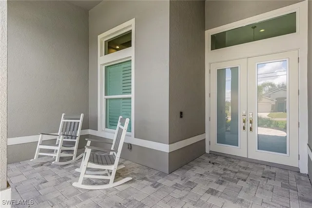 a view of an empty room with wooden floor and windows