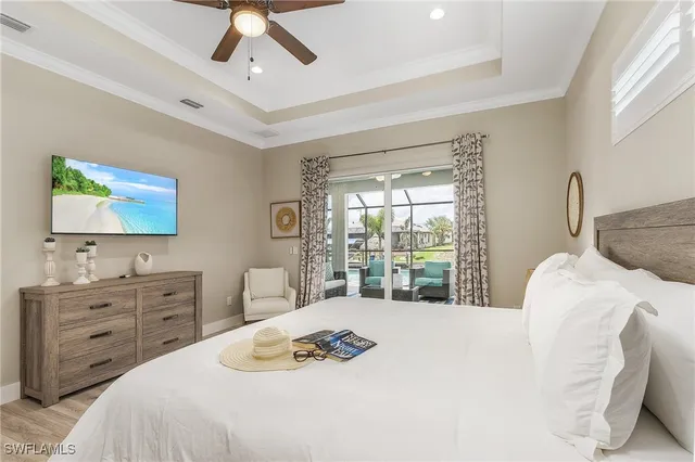 a bedroom with a bed and a flat tv screen on dresser