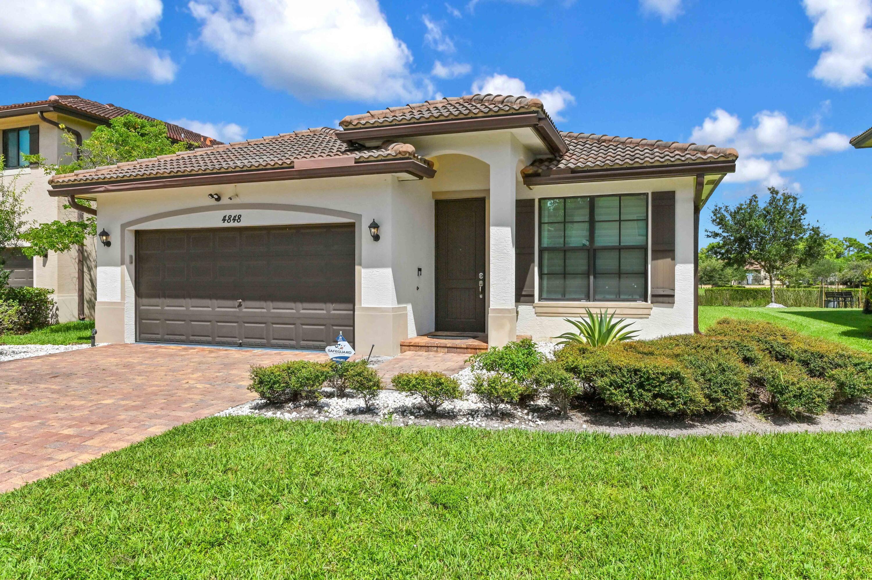 4848 Pond Pine Way Greenacres, FL 33463 - Photo 1 of 14 a front view of a house with a yard and garage