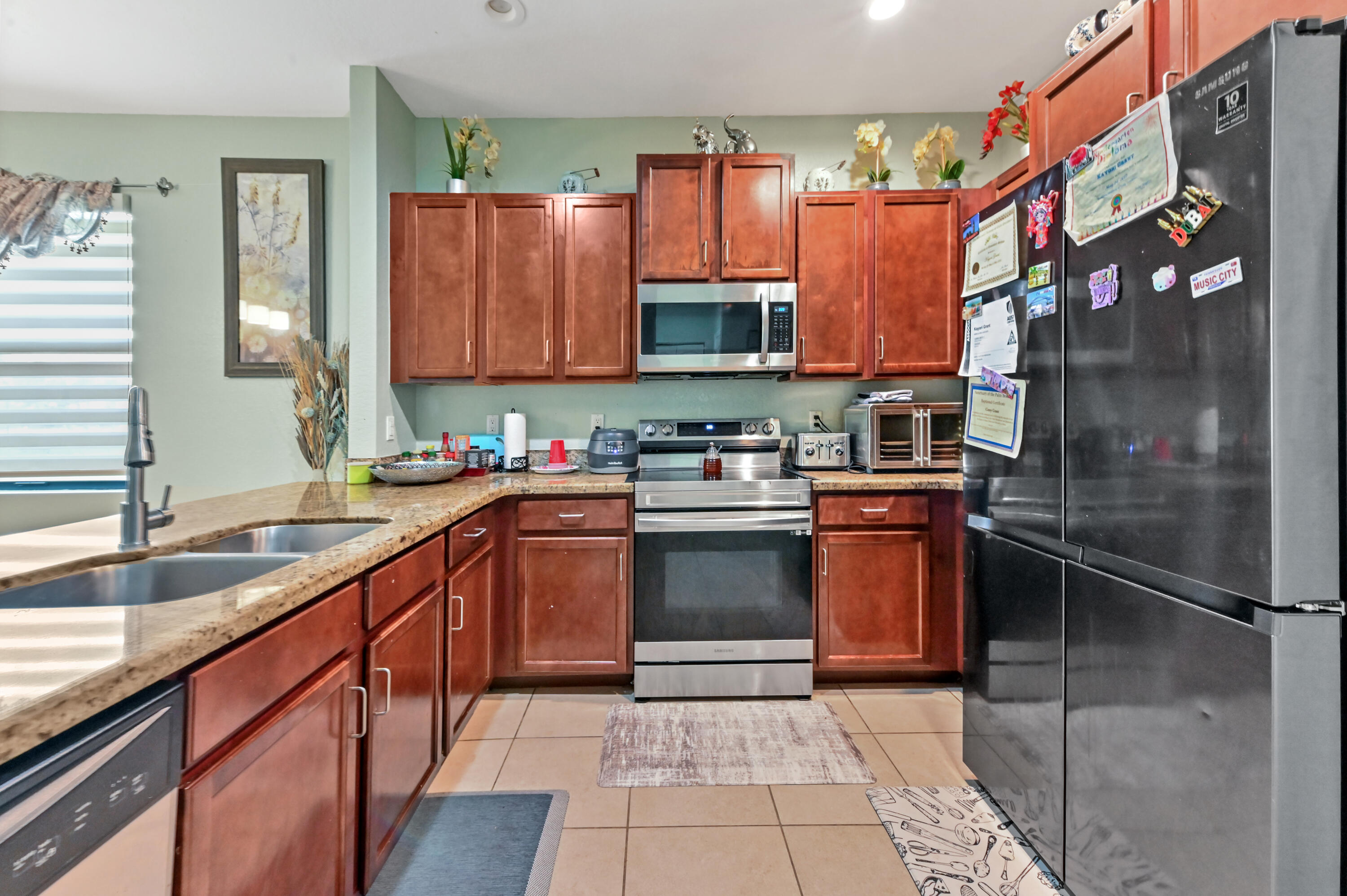 4848 Pond Pine Way Greenacres, FL 33463 - Photo 6 of 14 a kitchen with stainless steel appliances granite countertop a sink stove and refrigerator