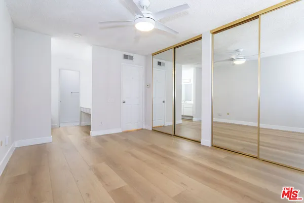 wooden floor in an empty room with a bathroom