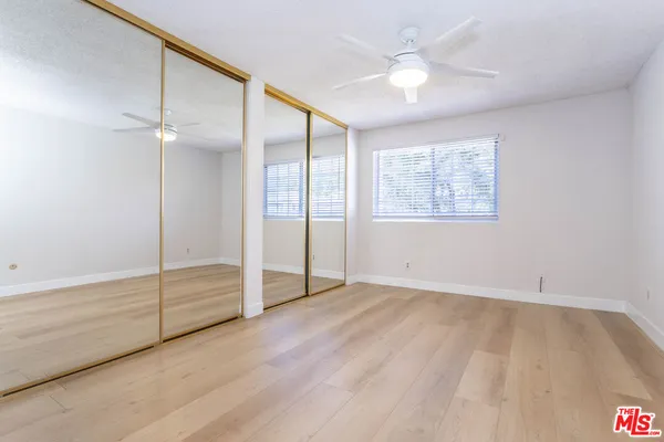 an empty room with fan and windows