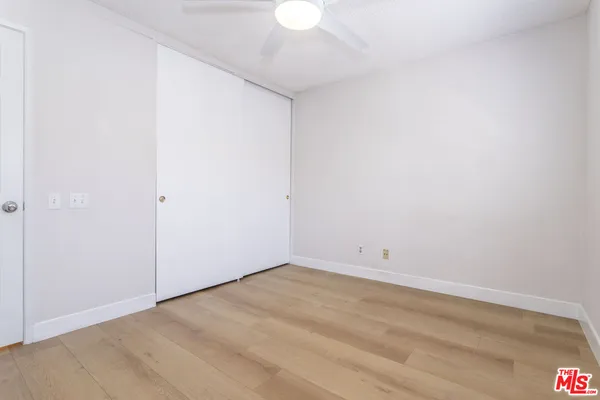 an empty room with a ceiling fan and a window