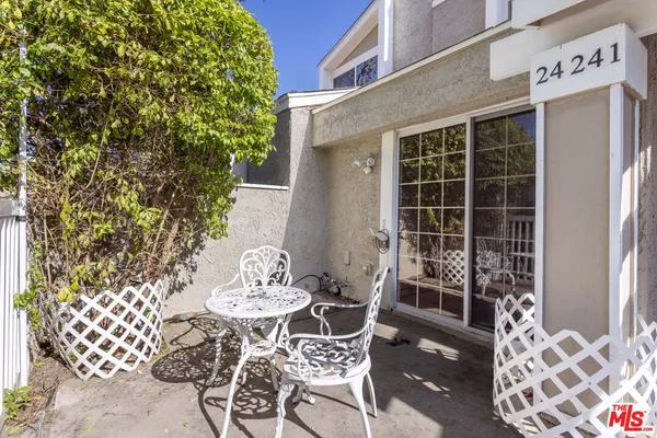 a view of a patio with table and chairs and potted plants