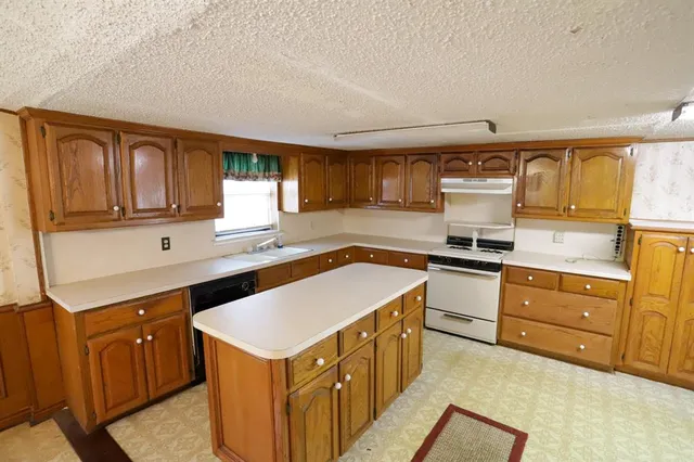 a kitchen with stainless steel appliances granite countertop a sink stove and cabinets