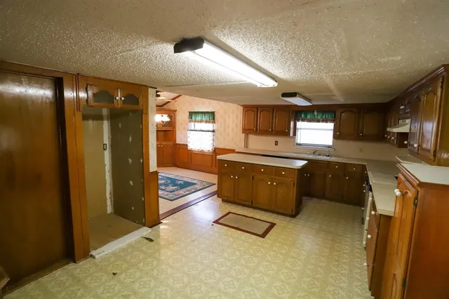 a kitchen with stainless steel appliances granite countertop a refrigerator a sink and a stove