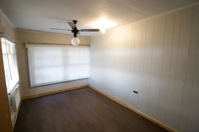 en empty room with windows and ceiling fan