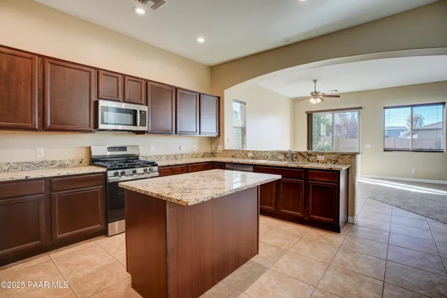 a kitchen with stainless steel appliances granite countertop a stove a sink and a microwave
