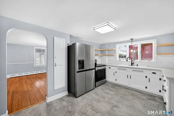 a large kitchen with granite countertop a refrigerator and a sink
