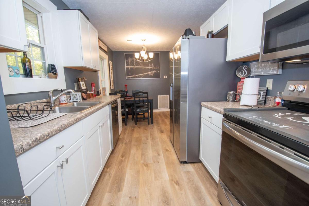 1104 Alverson Road LaGrange, GA 30241 - Photo 11 of 25 a kitchen with granite countertop a sink stove and cabinets