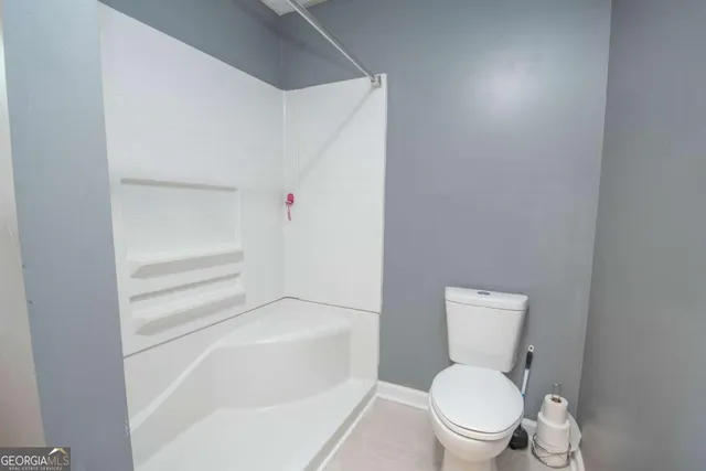 a white toilet sitting next to a bath tub