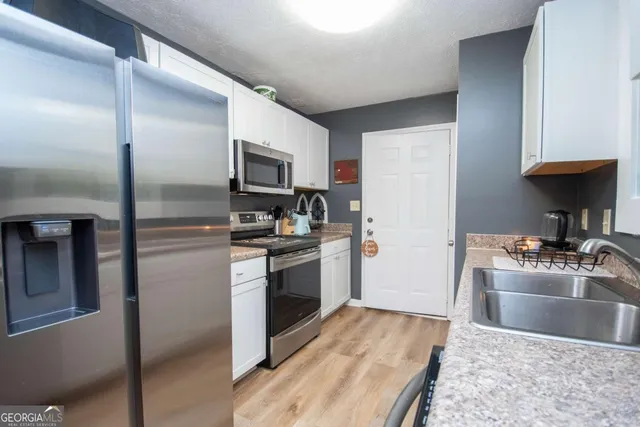 a kitchen with granite countertop a refrigerator stove and sink