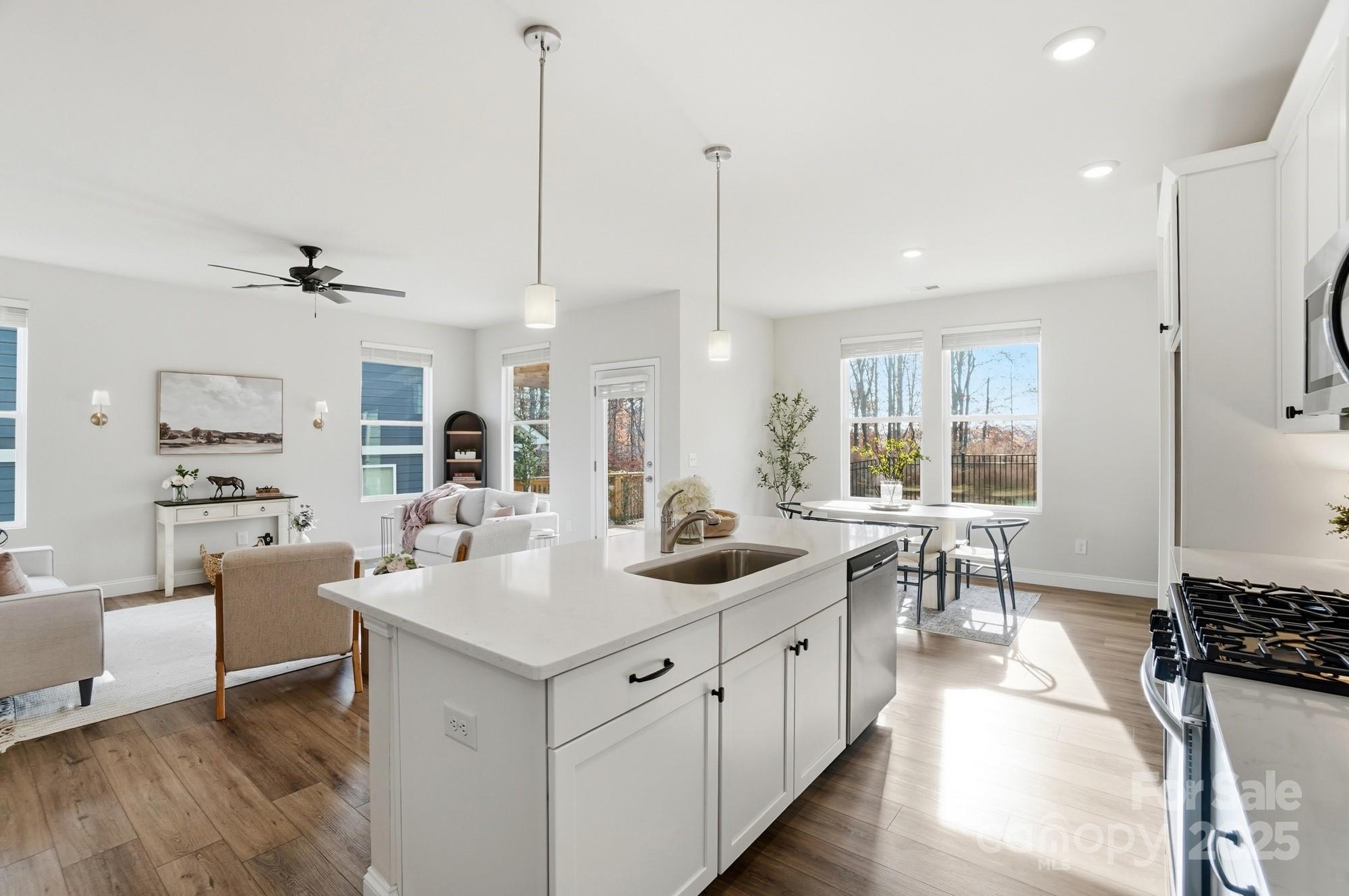 256 Hamrick Road, Unit 12 Cramerton, NC 28056 - Photo 13 of 41 a open kitchen with stainless steel appliances granite countertop a sink dishwasher a stove and a dining table with white cabinets