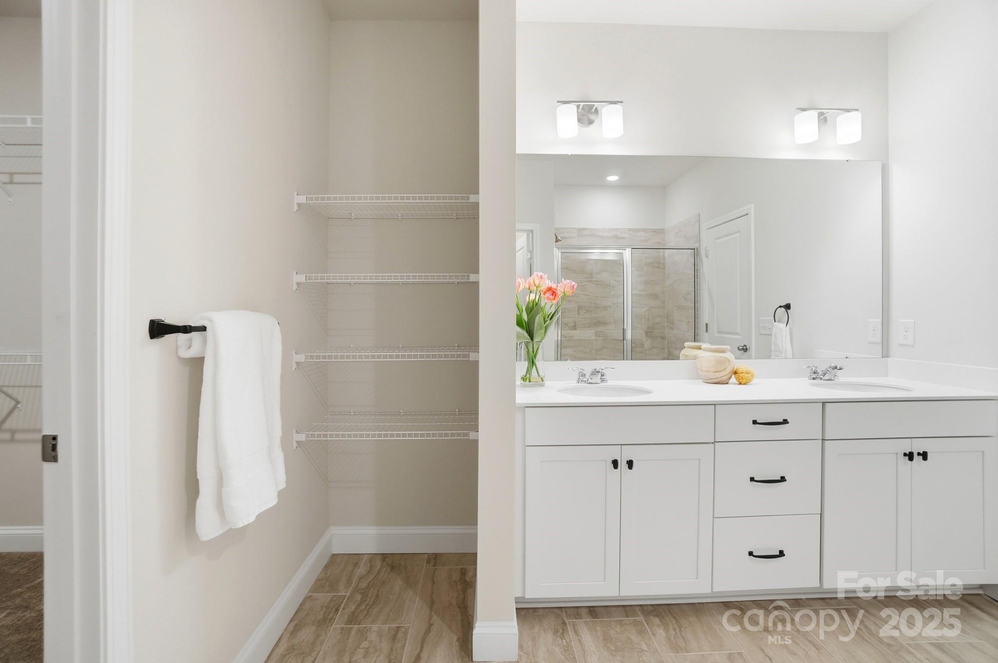 256 Hamrick Road, Unit 12 Cramerton, NC 28056 - Photo 28 of 41 a bathroom with a granite countertop sink a mirror and a shower