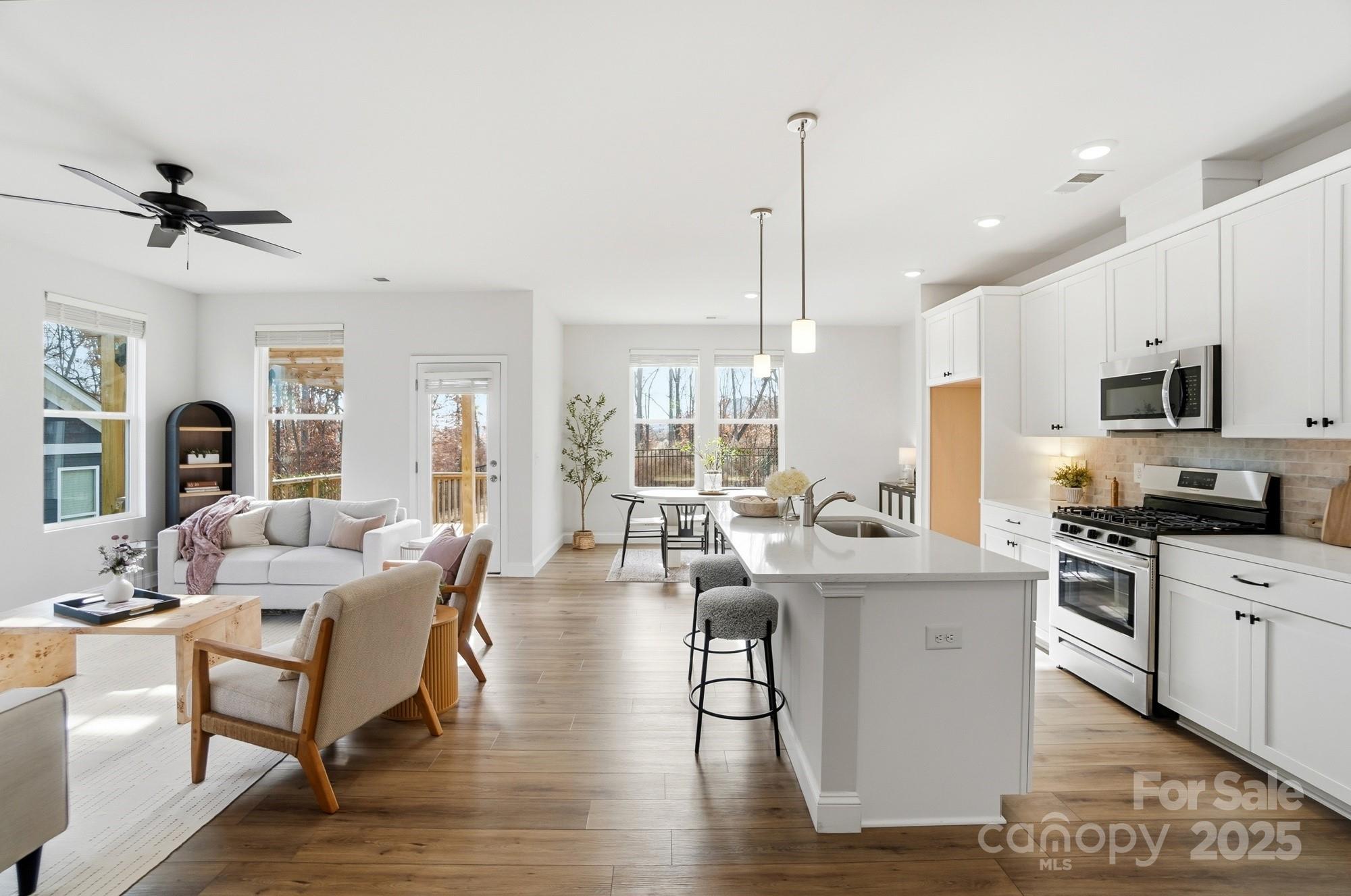 256 Hamrick Road, Unit 12 Cramerton, NC 28056 - Photo 9 of 41 a view of a kitchen with kitchen island stainless steel appliances a stove a sink a center island and furniture