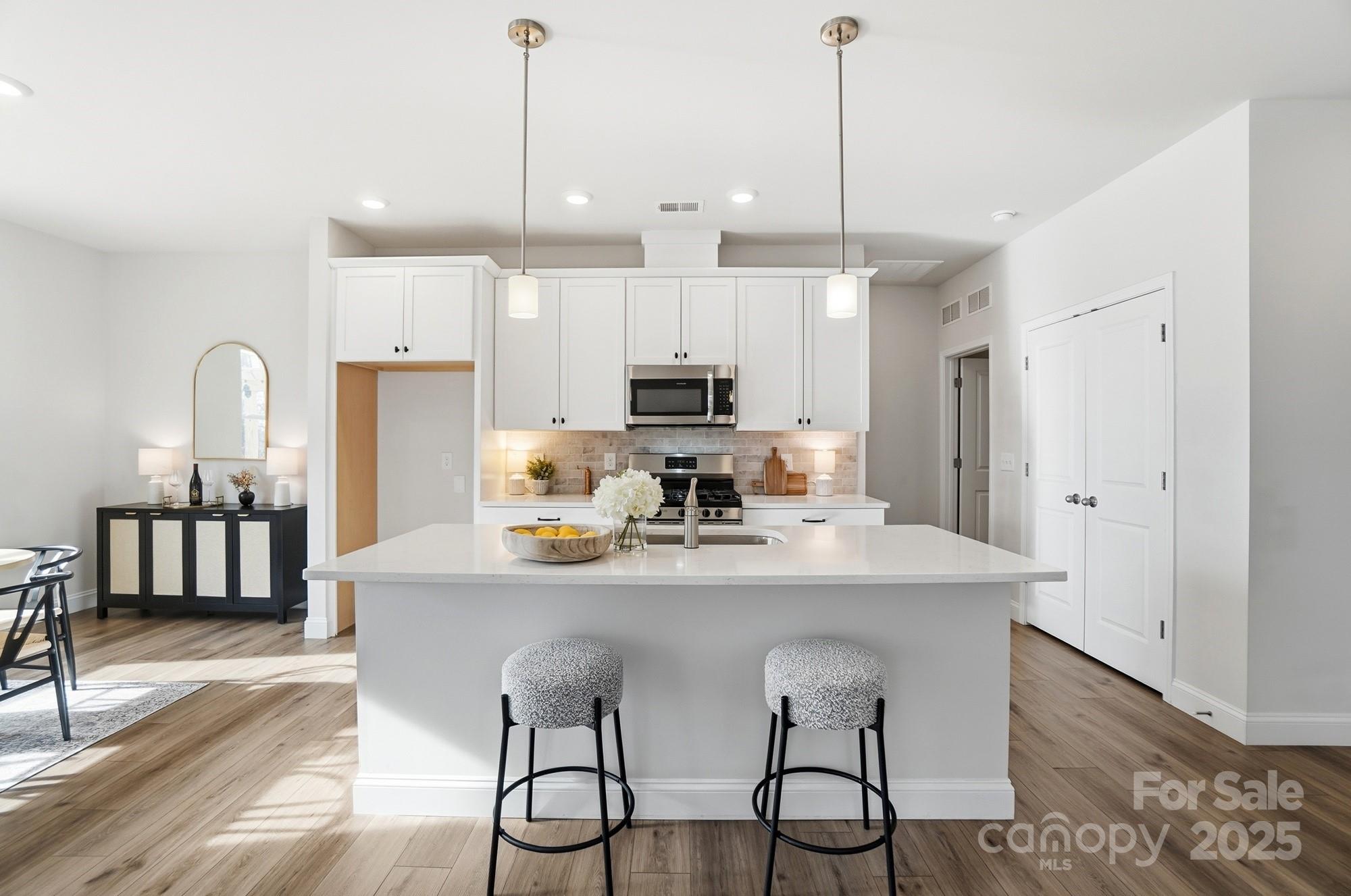 256 Hamrick Road, Unit 12 Cramerton, NC 28056 - Photo 10 of 41 a kitchen with stainless steel appliances kitchen island granite countertop a dining table chairs and a refrigerator