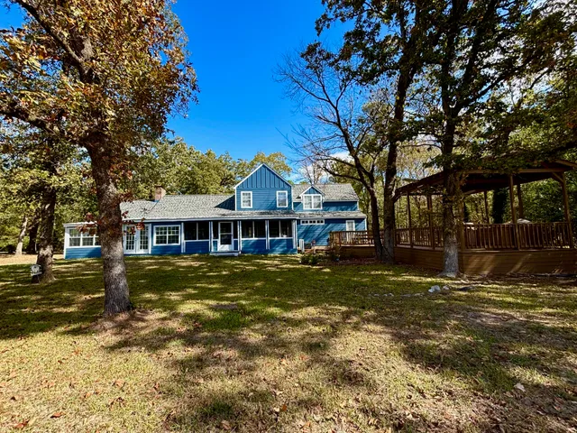 a view of a big house with a big yard and large trees